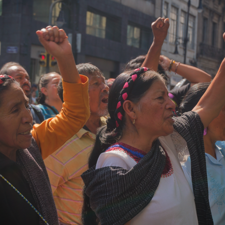 Tres mujeres mazatecas alzan su puño frente a sus compañeras que entran a la SCJN